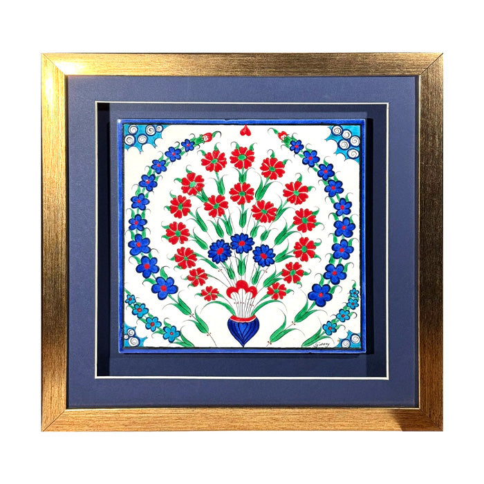 Decorative iznik tile with floral design framed in gold on a white background