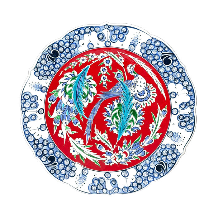Decorative iznik ceramic plate with peacock design on a red background