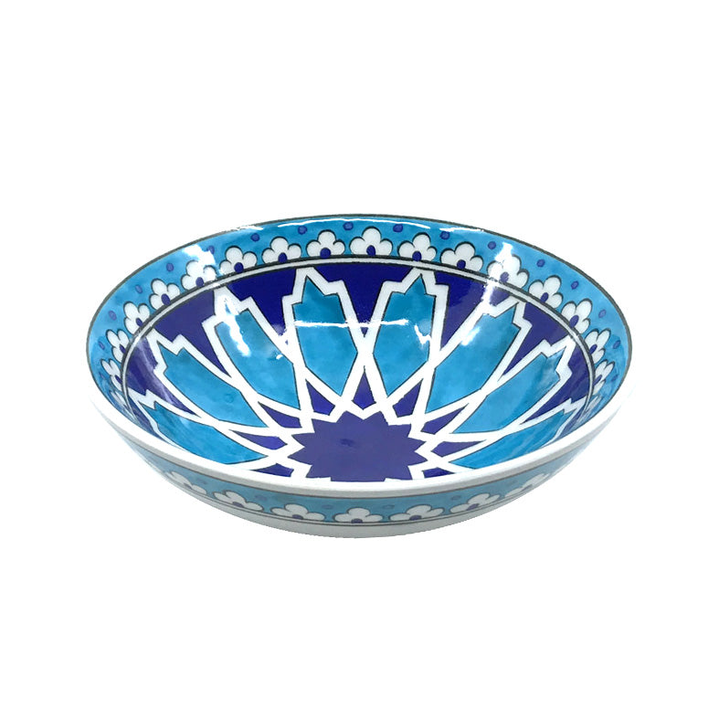 Decorative iznik bowl with blue and white geometric pattern on a white background